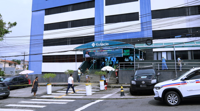 Imagem da fachada da faculdade onde as provas foram realizadas. Candidatos entram na instituição.
