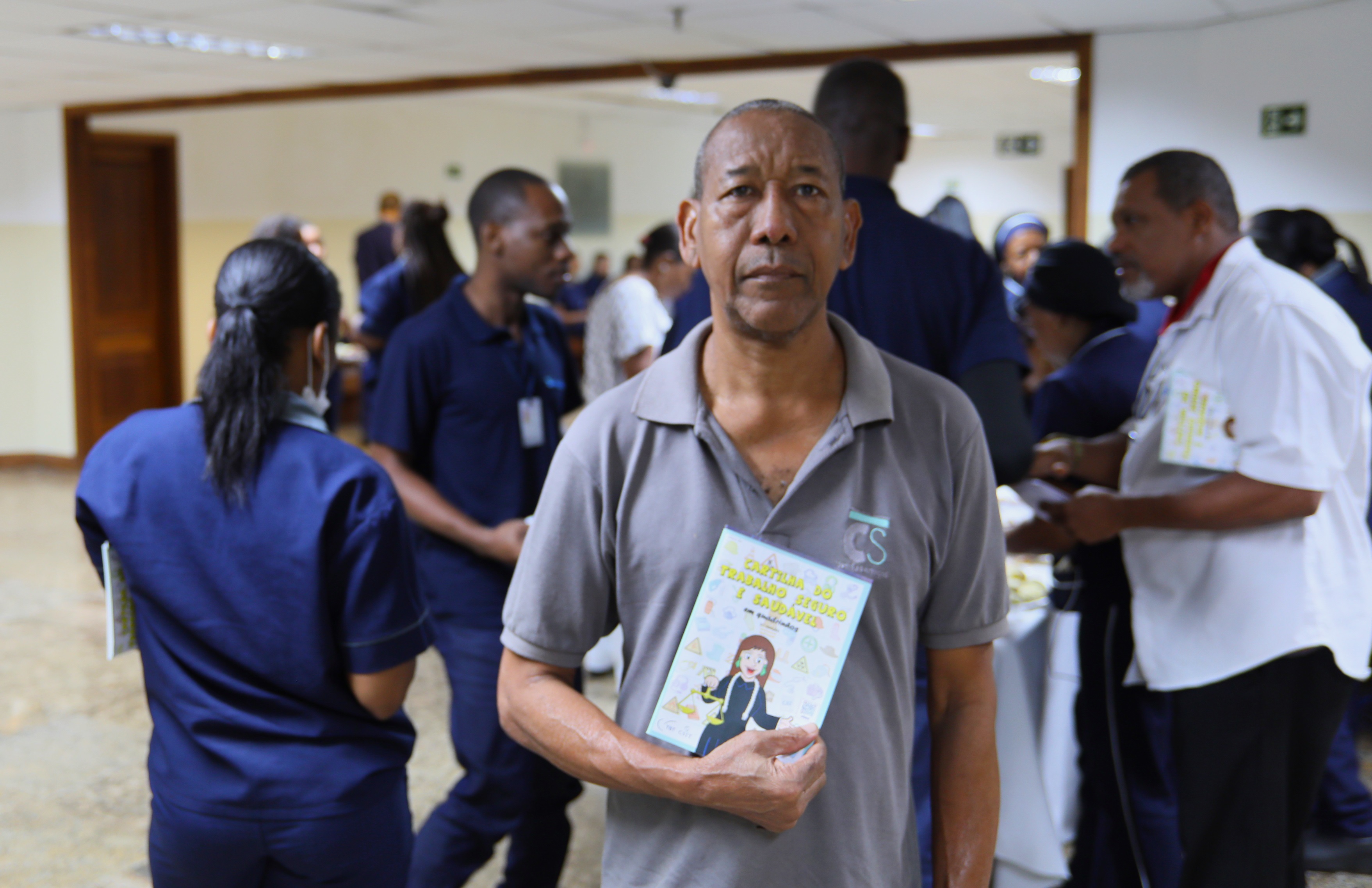 Jorge Luiz da Conceição está em pé segurando um panfleto que foi distribuído