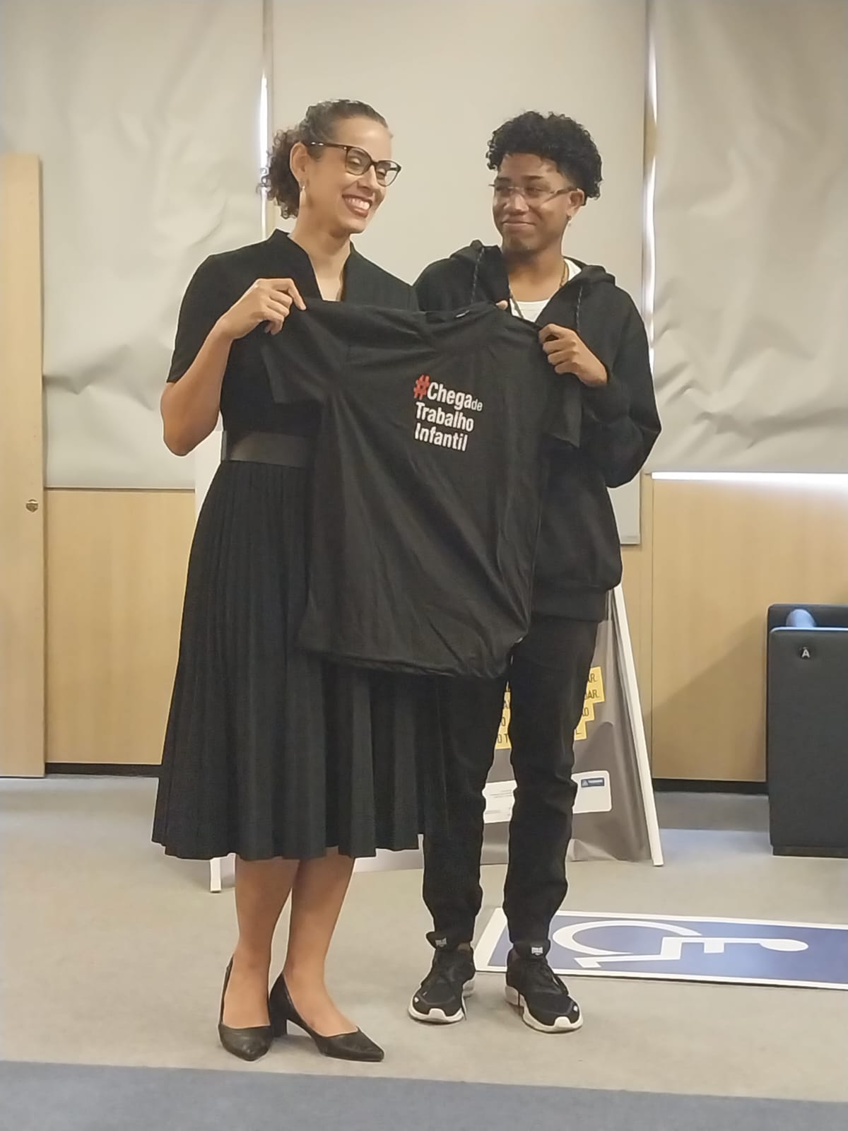 Juíza apresenta camisa preta onde está escrito "Chega de trabalho infantil"